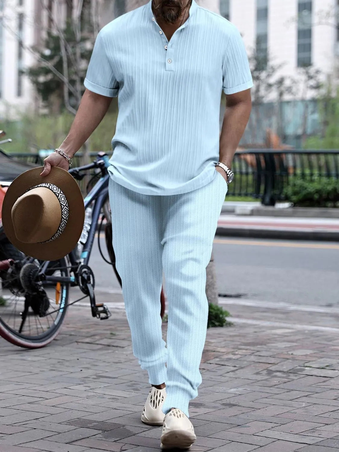Men's full size button detail short sleeve top and pants set in light blue, slightly stretchy fabric walking outdoors.