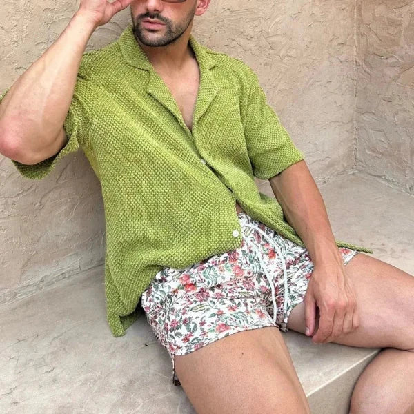 Luxury men's beach wear set with green short-sleeved shirt and floral drawstring shorts.