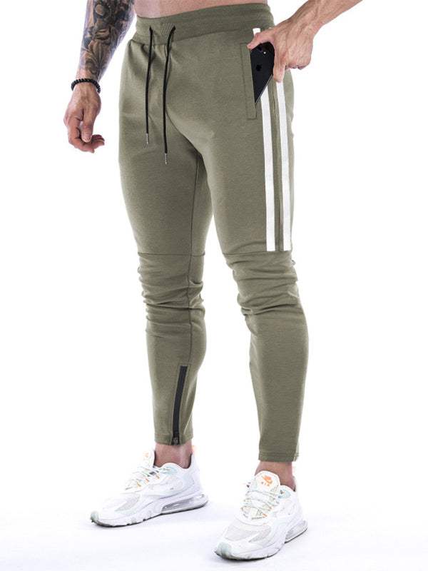 Men's training joggers with contrasting stripe and zipper detail.