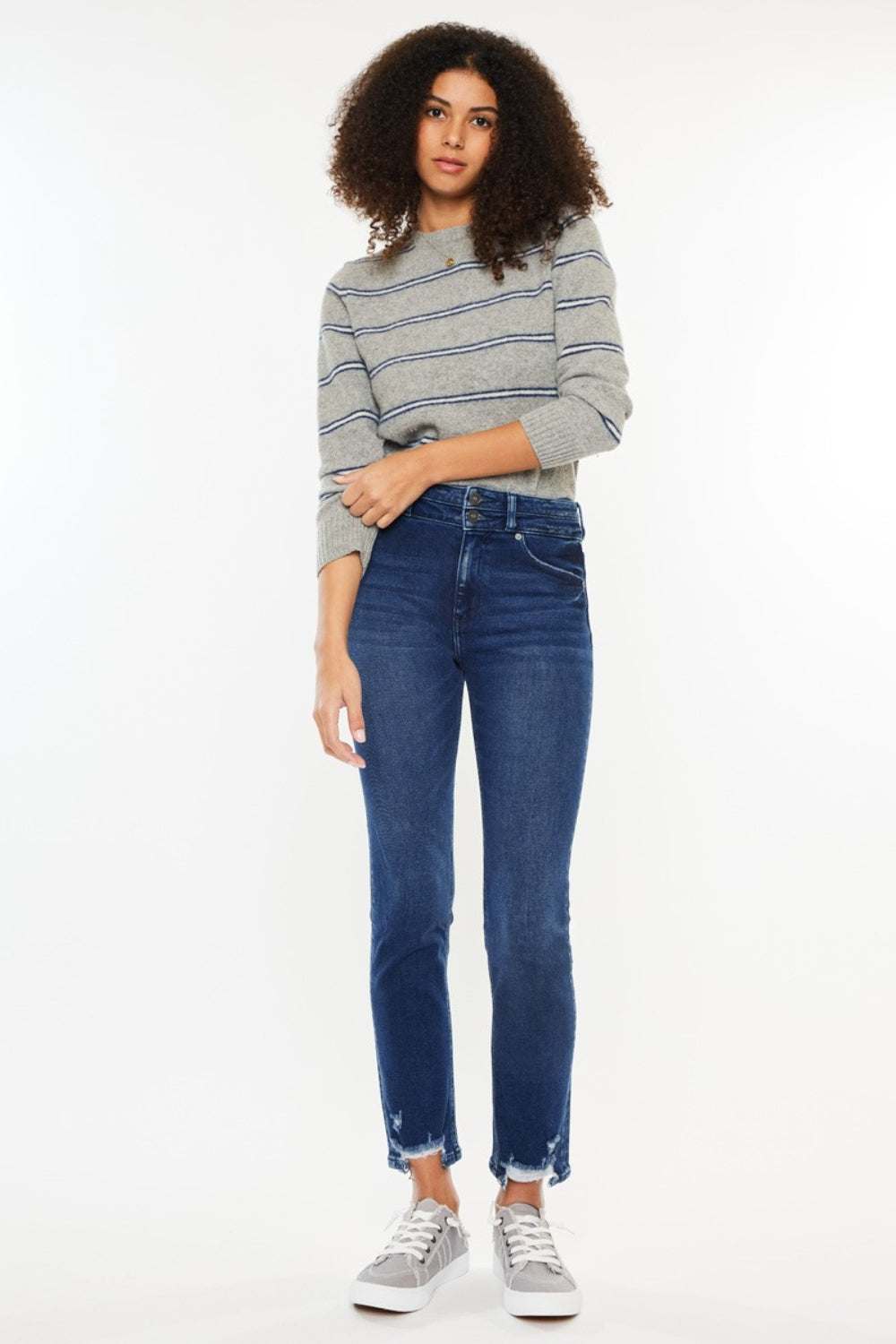 High Rise Slim Straight Jeans on person with striped sweater and sneakers.
