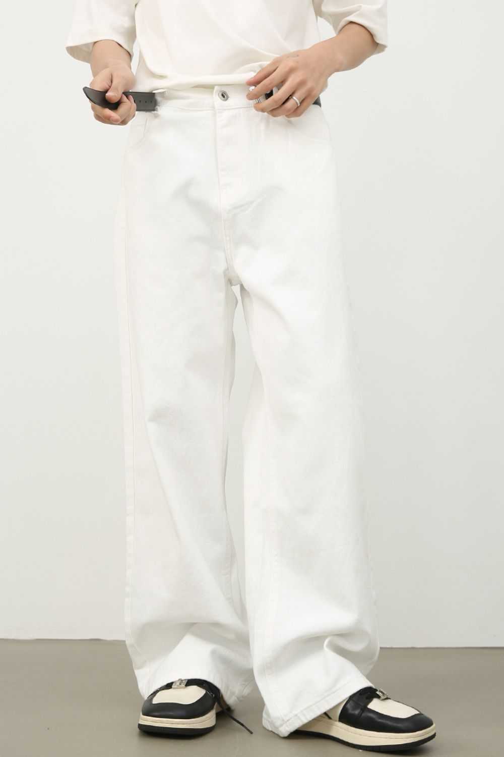 Men's white wide straight leg jeans made of 100% cotton, no stretch, paired with sneakers.
