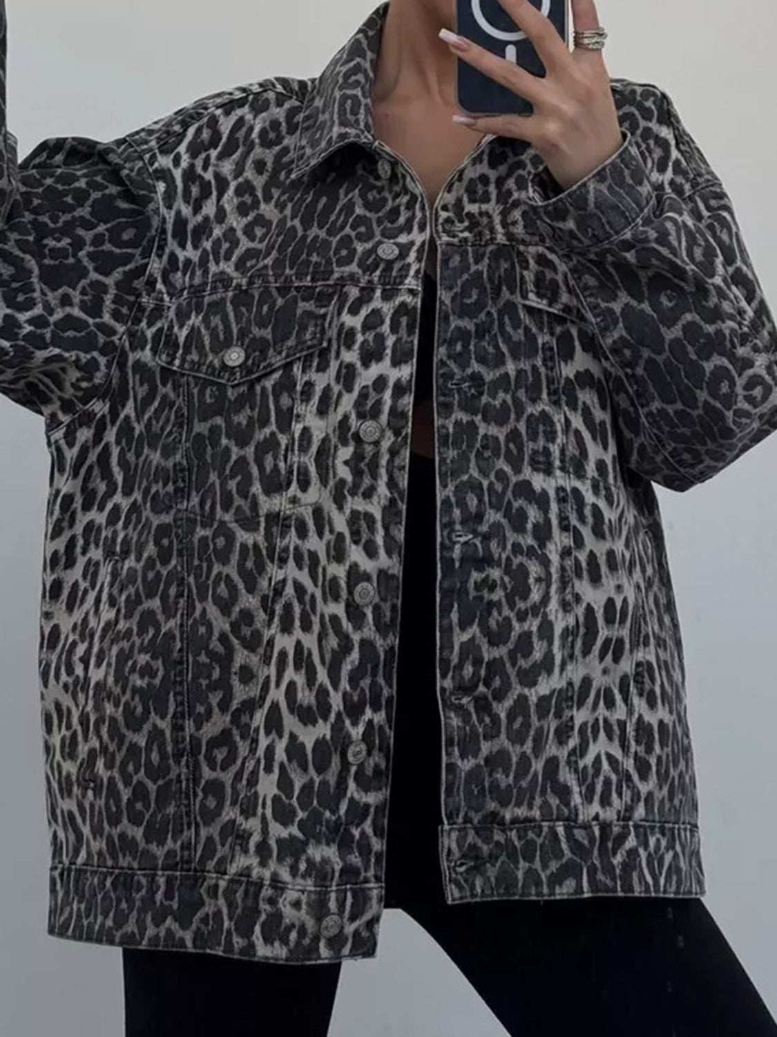 Leopard print button-up denim top with long sleeves and pockets.