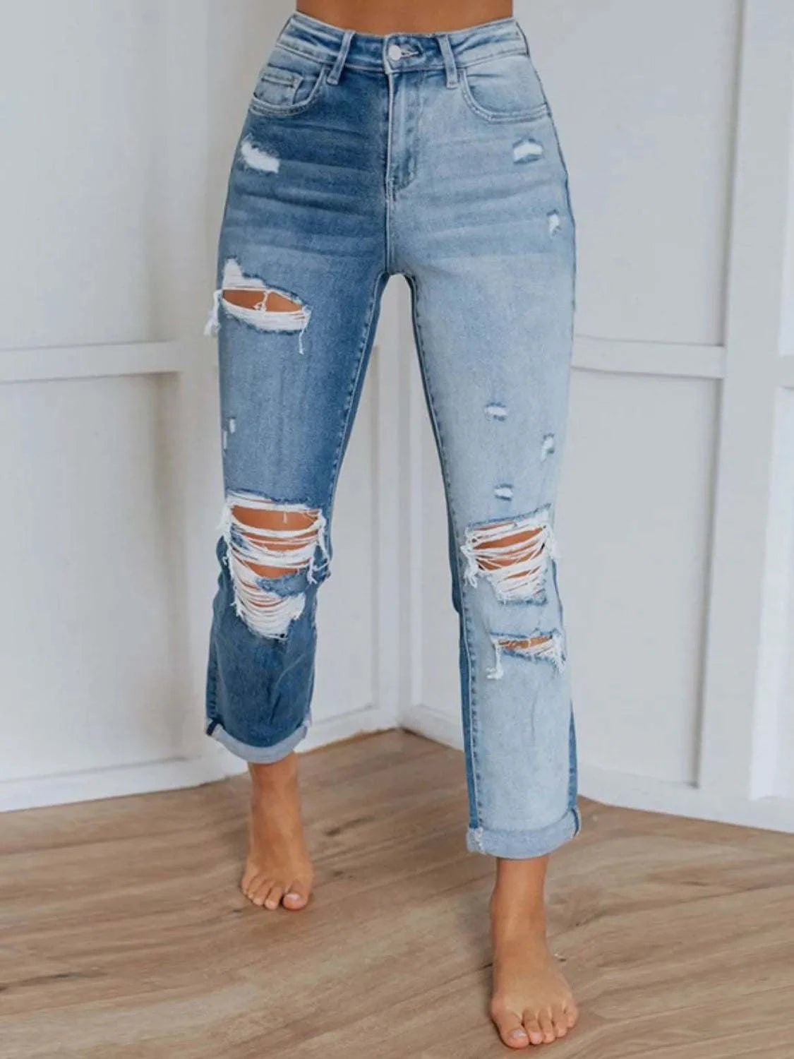 Distressed jeans with buttoned design and pockets featuring slight stretch in cotton-polyester blend.