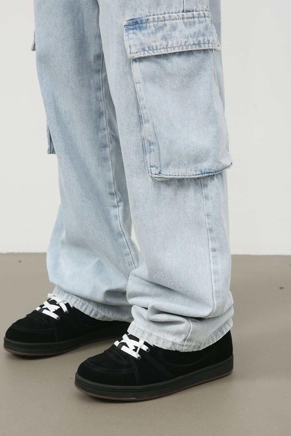 Men's wide leg jeans with cargo pockets, light wash, no stretch, cotton blend material.