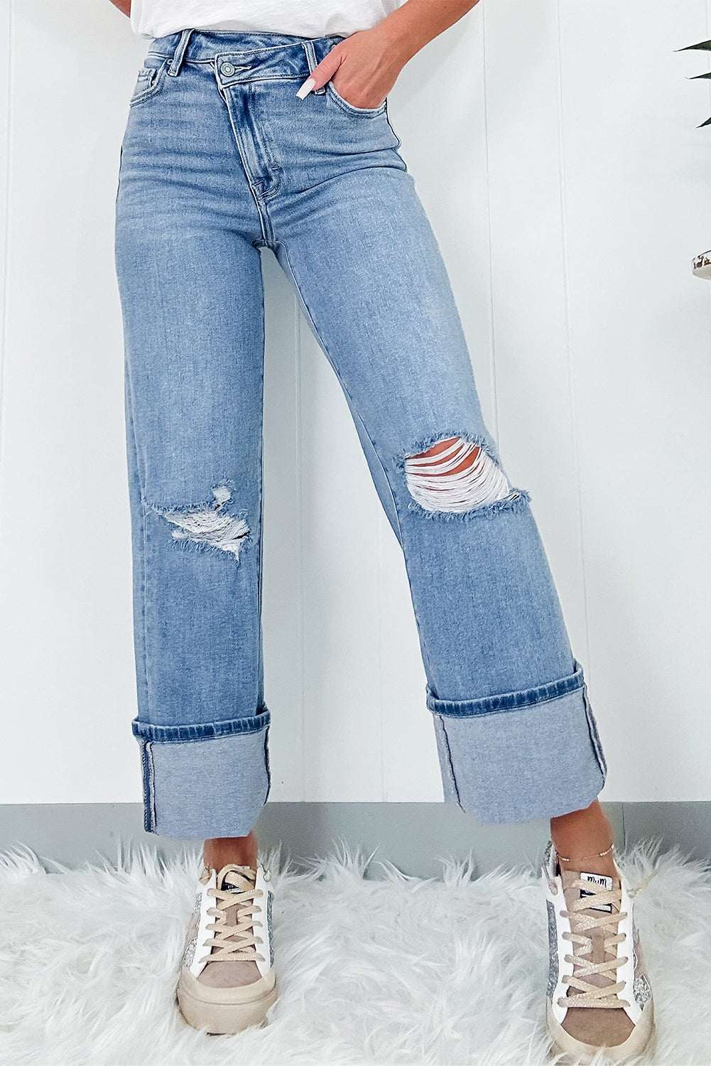 Distressed straight jeans with pockets featuring ripped details and slightly stretchy material.