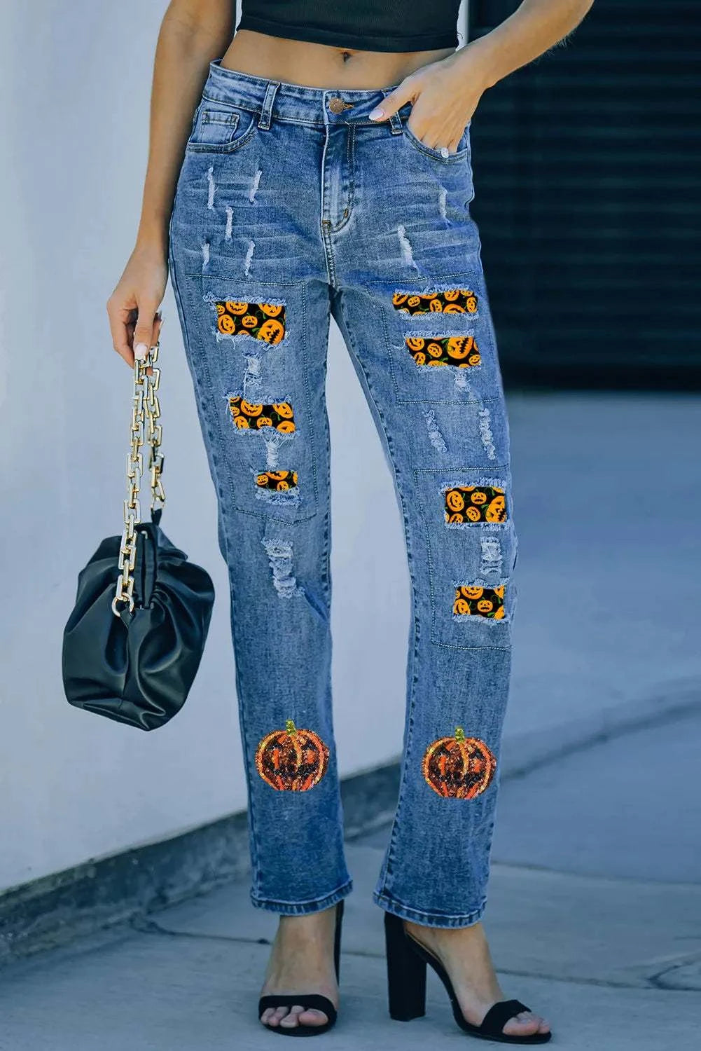 Distressed straight jeans with sequin pumpkin design, slightly stretchy fabric, and unique detailing.
