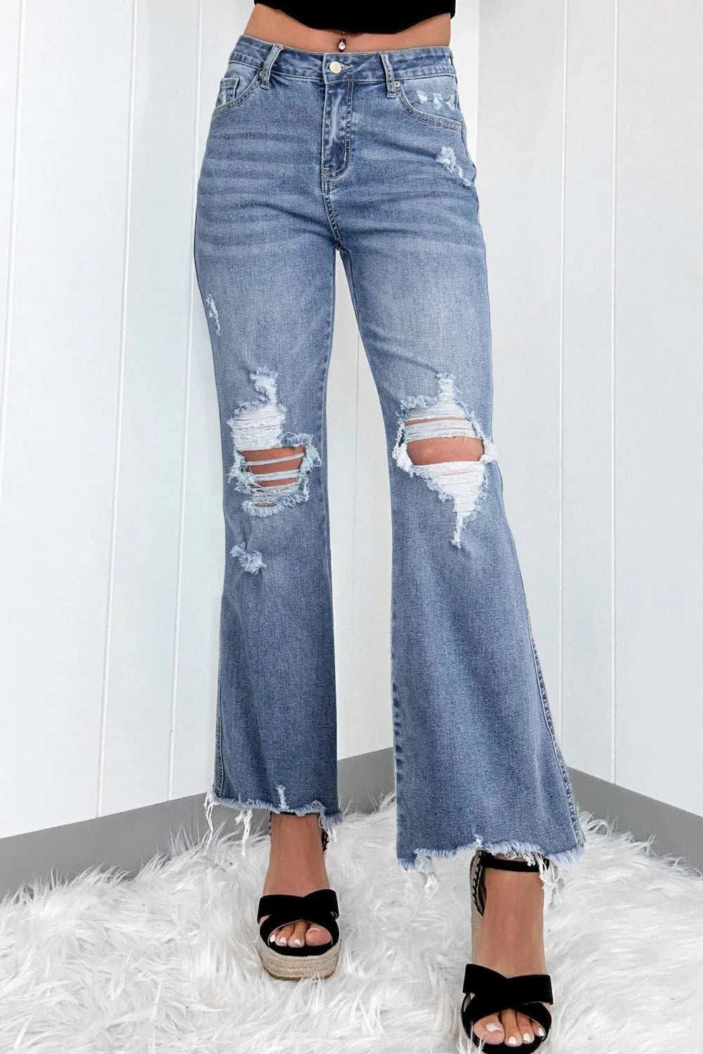 Distressed raw hem bootcut jeans with slightly stretchy fabric.