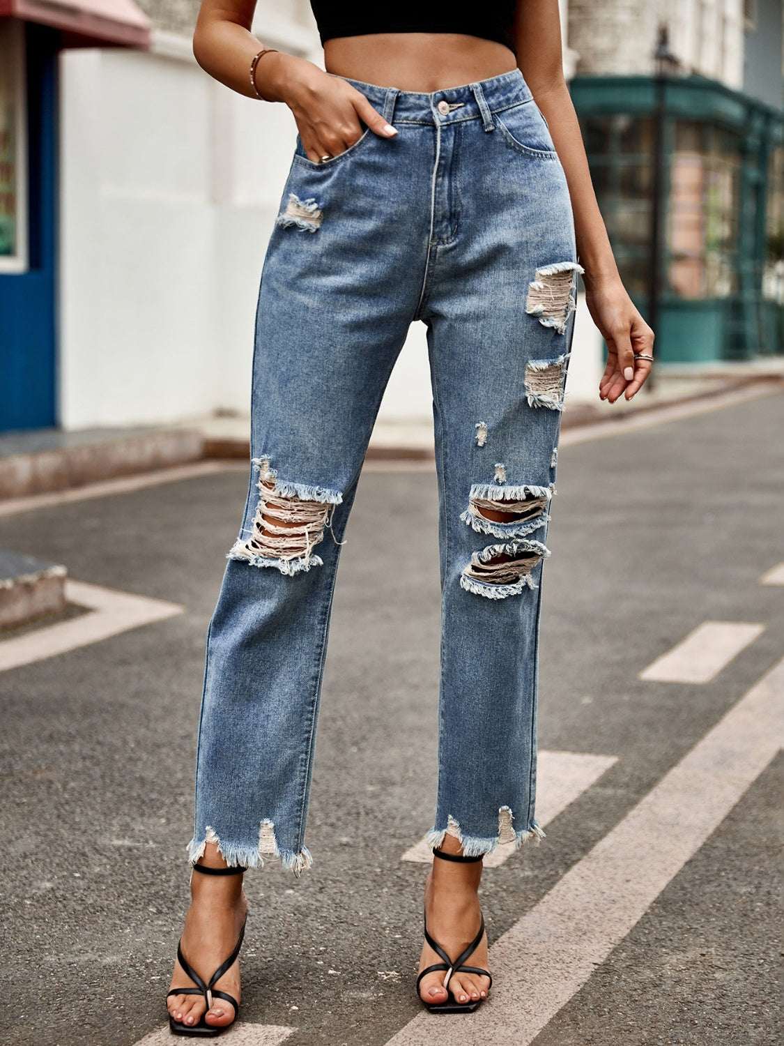 Distressed raw hem jeans with pockets and button closure.