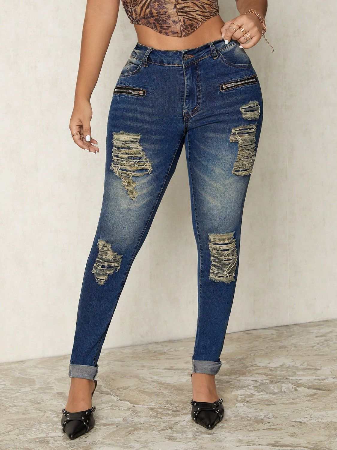 Distressed skinny jeans with buttoned pockets and ripped detailing.