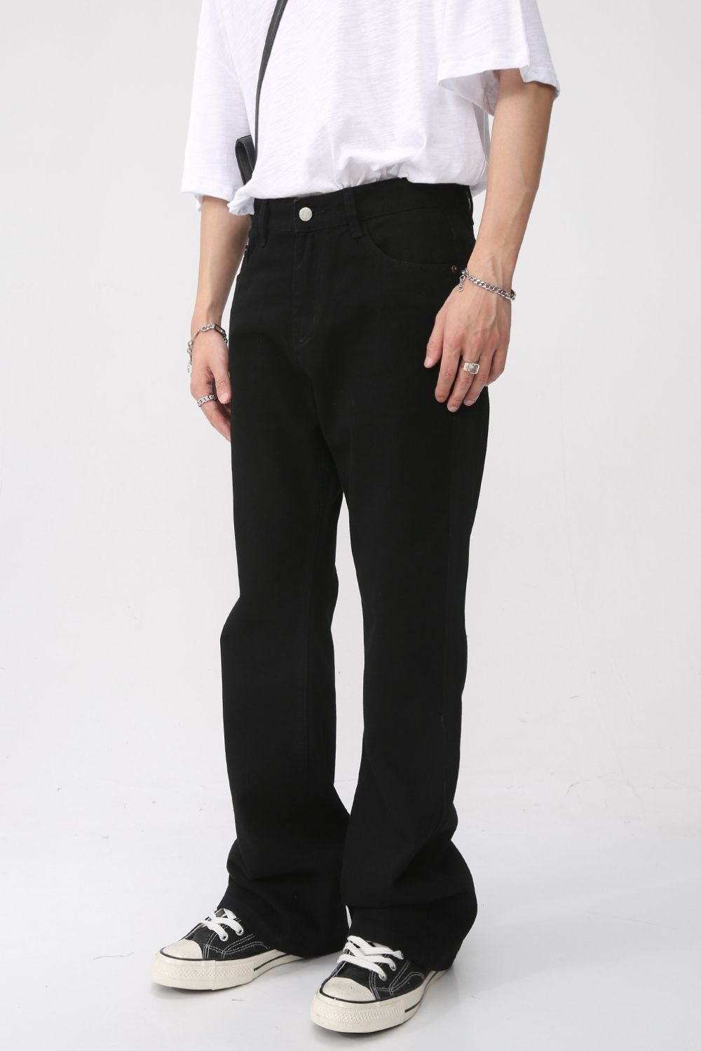 Mid rise black jeans with pockets worn by a model, basic style, no stretch.