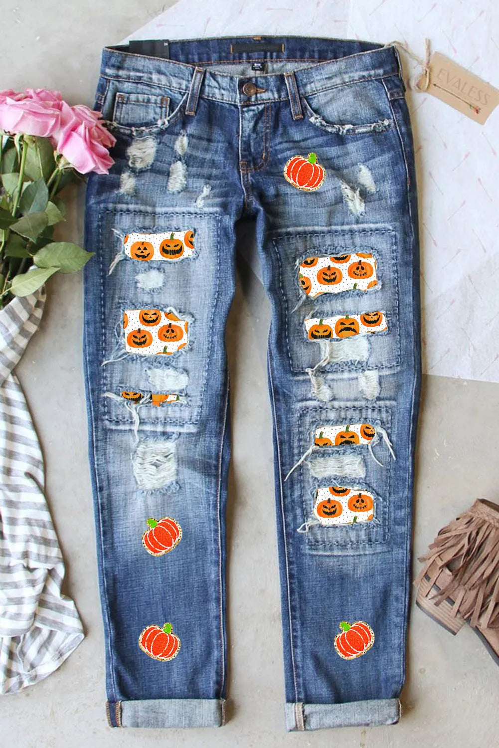 Distressed pumpkin-themed jeans with pockets, slightly stretchy denim.