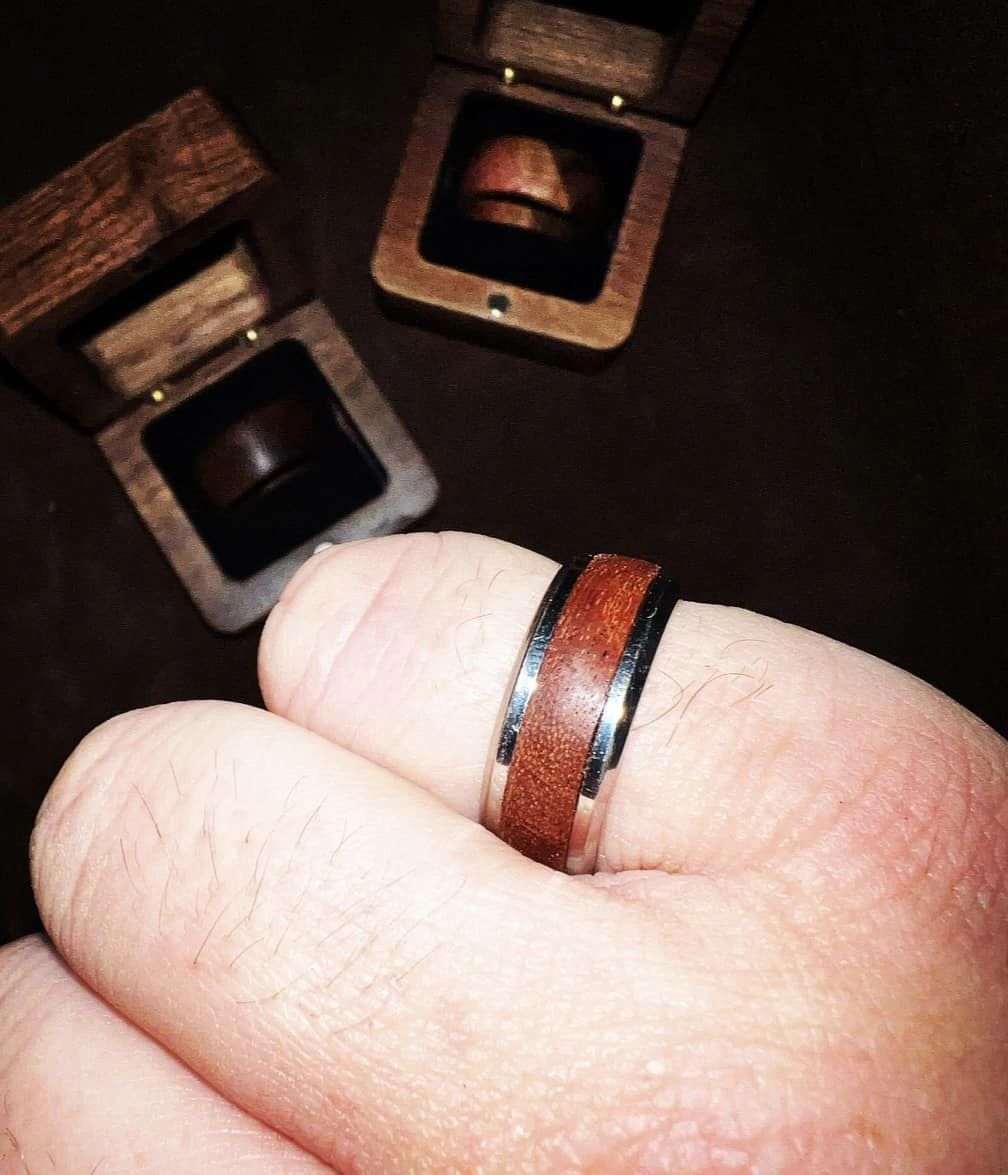 Walnut wood ring with stainless steel core and comfort fit, displayed with two wooden ring boxes.