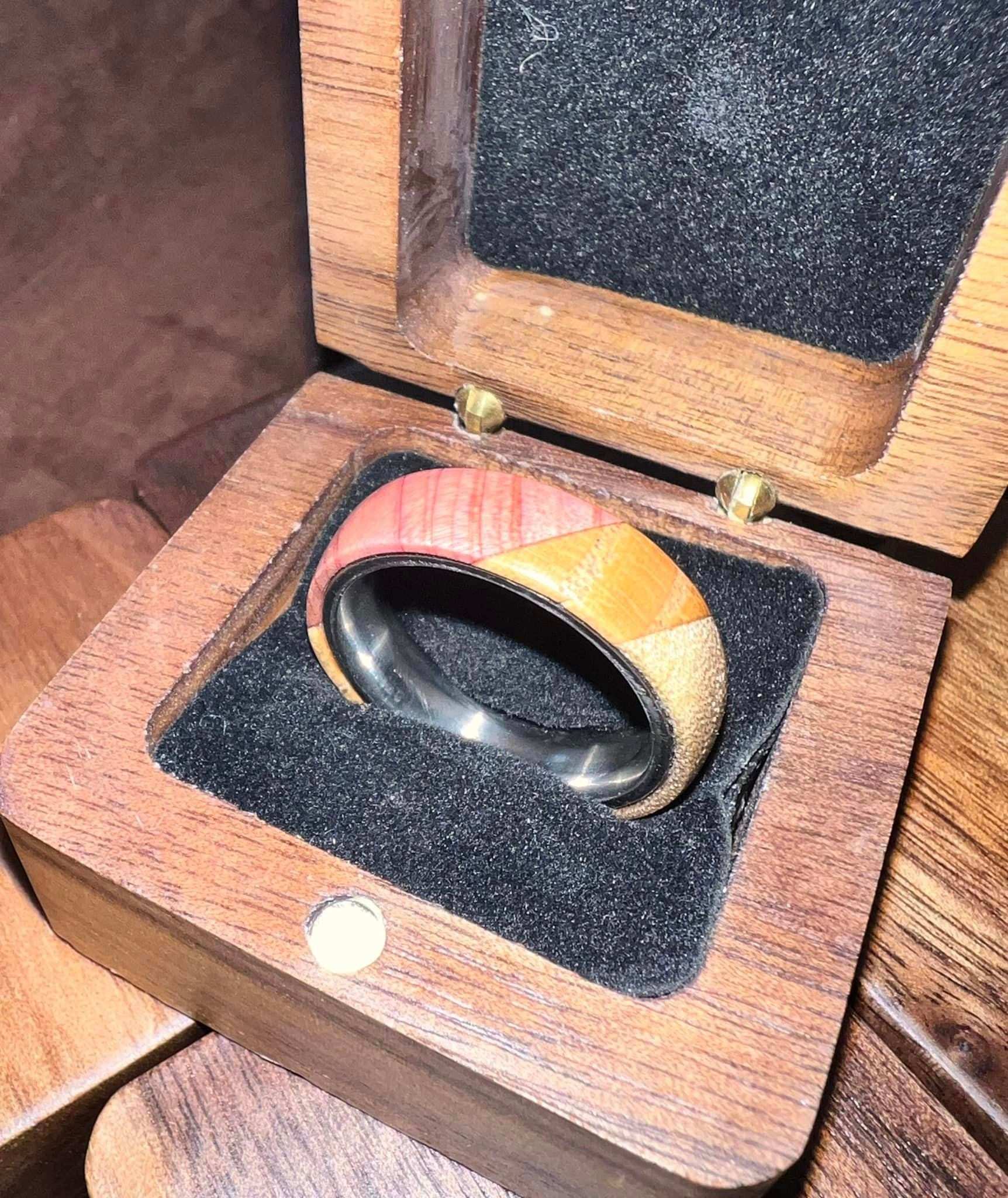 Titanium wooden tri colored ring with Cedar, Oak, and Walnut in a wooden box.