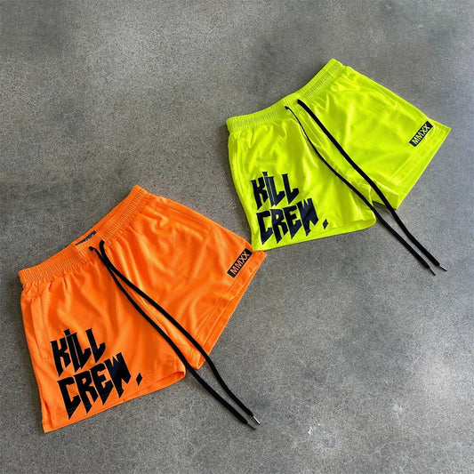 Casual Quick Dry beach shorts in vibrant orange and yellow, featuring bold graphic text on a concrete background.