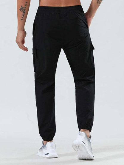Men's quick-drying black cargo pocket trousers with elastic waist, suitable for fitness training and casual wear.