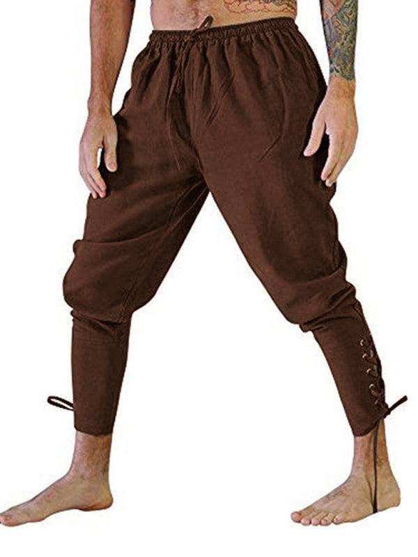 Men's brown cuffed ankle trousers with ankle strap design.