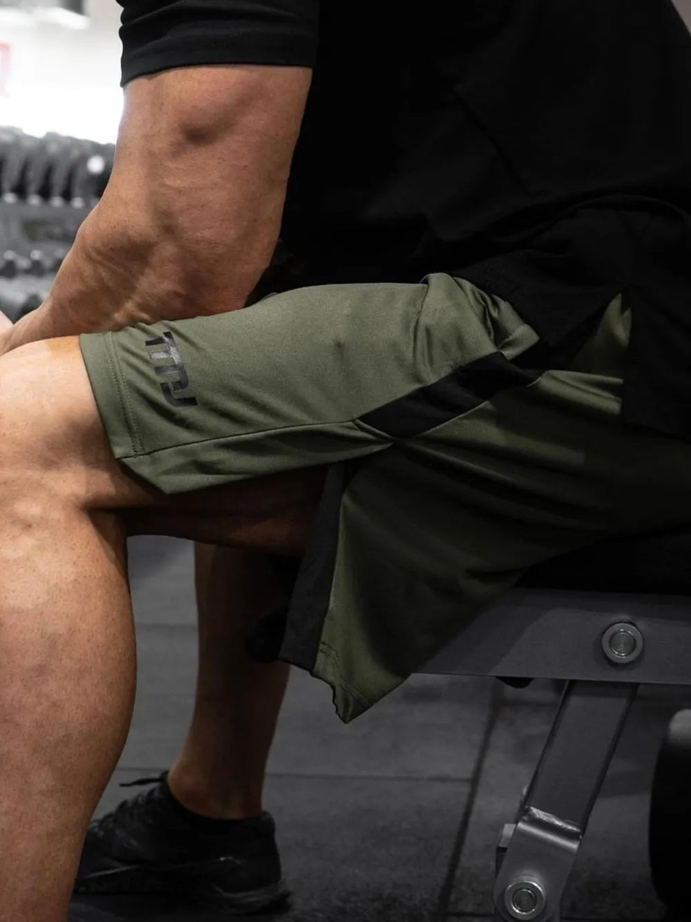 Men's plus size side slit shorts in gym setting.