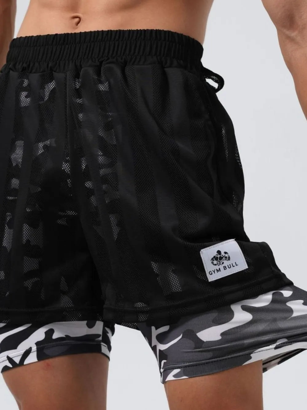 Men's plus size elastic waist black shorts with camo pattern, 100% polyester, displayed on a model.