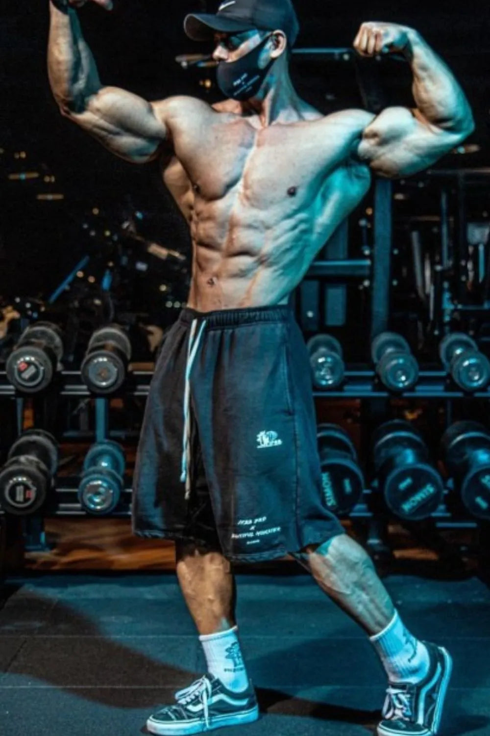 Men's plus size graphic drawstring active shorts in gym setting.