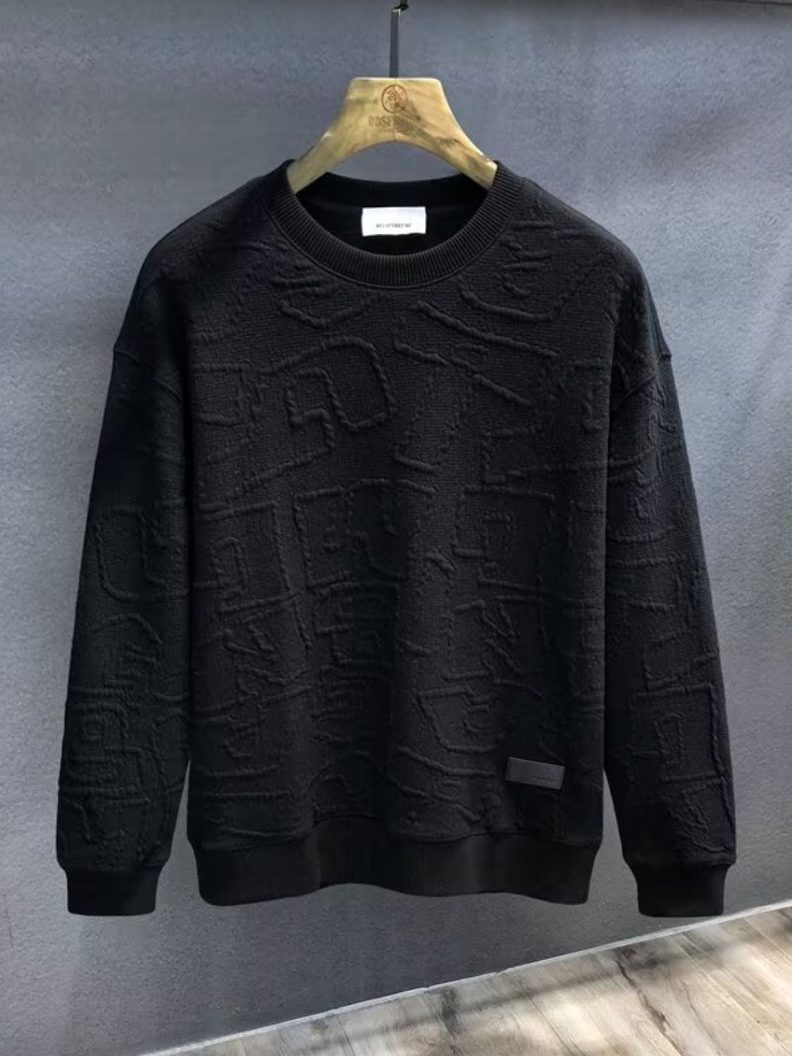 Men's plus size black textured round neck long sleeve sweatshirt on hanger.