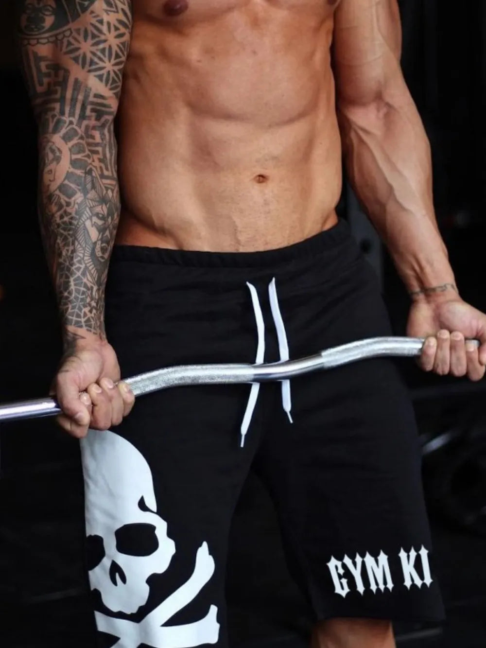 Men's Skull Drawstring Shorts, made from 95% cotton and 5% polyester, showing a skull design on a model who is lifting a barbell.