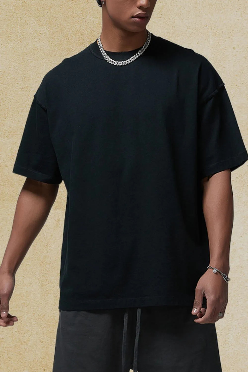 Men's round neck half sleeve t-shirt in black, worn casually.