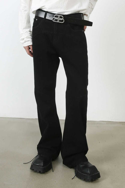 Men's mid rise jeans with pockets, black color, styled with a belt.