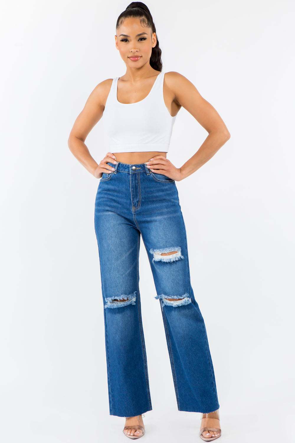 High Waist Distressed Wide Leg Jeans with ripped detailing and raw hem worn by a model.