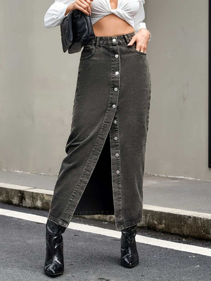 Button up high rise denim skirt with front buttons, pockets, and slit detail.