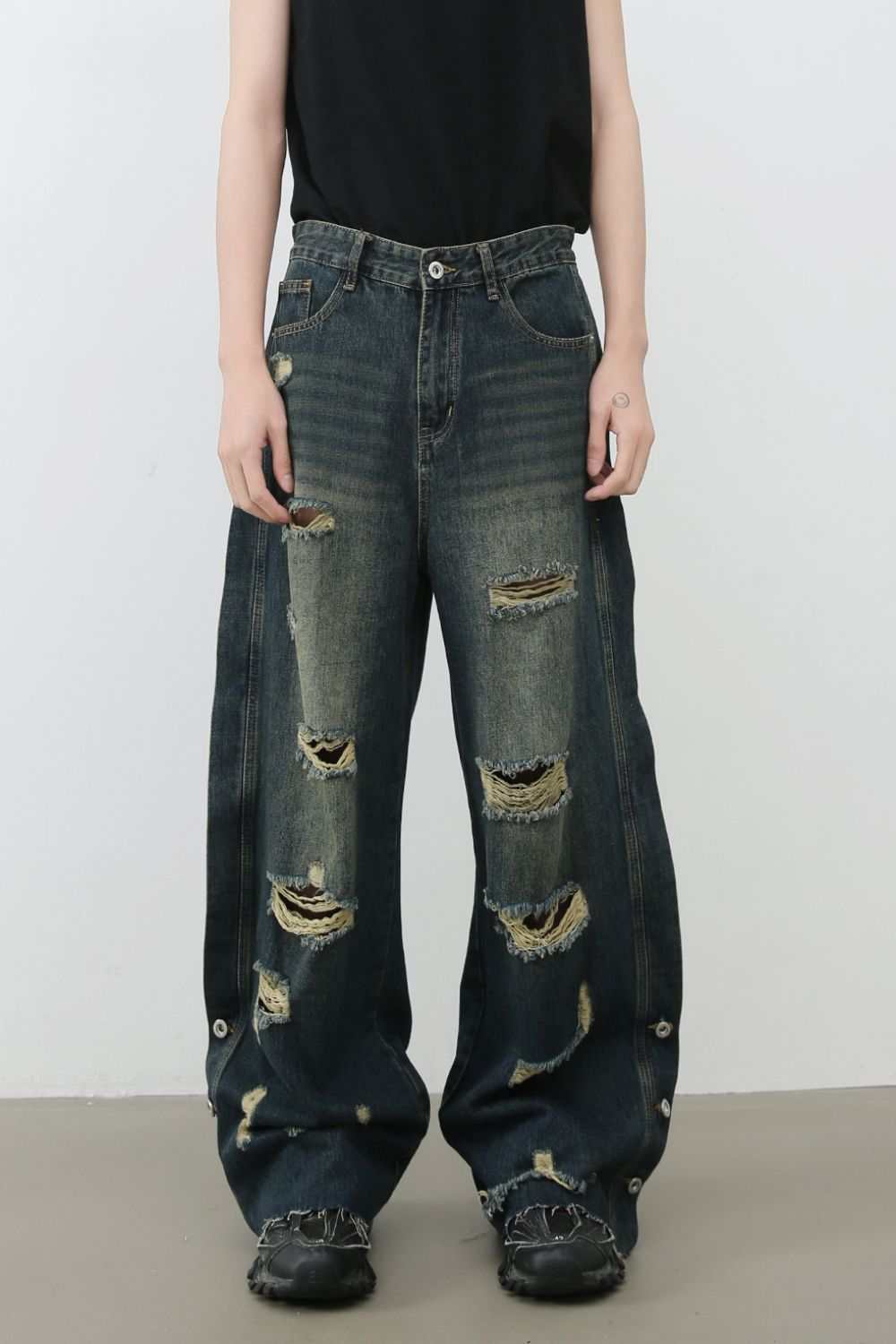 Men's frayed hem distressed wide leg jeans with raw edge detailing.