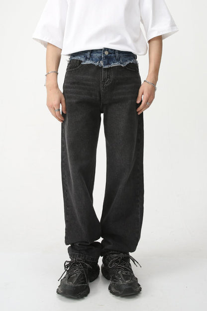 Men's spliced raw hem straight leg jeans, black fabric, modeled with a white shirt and black shoes.