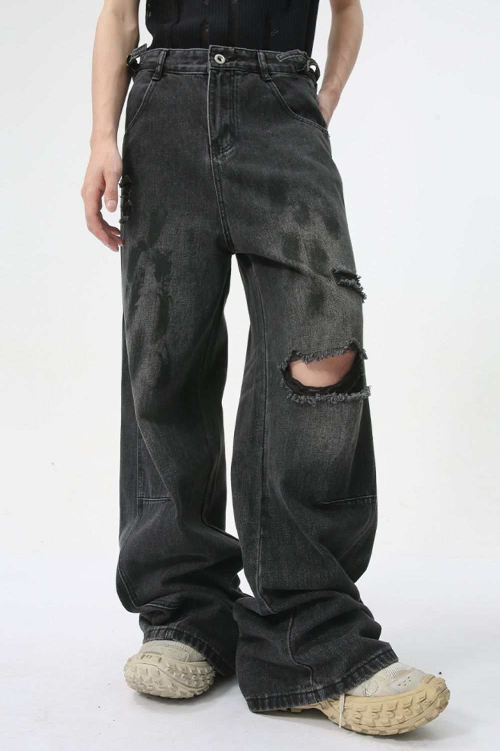 Distressed jeans with pockets, slightly stretchy fabric, black color, ripped knee design.