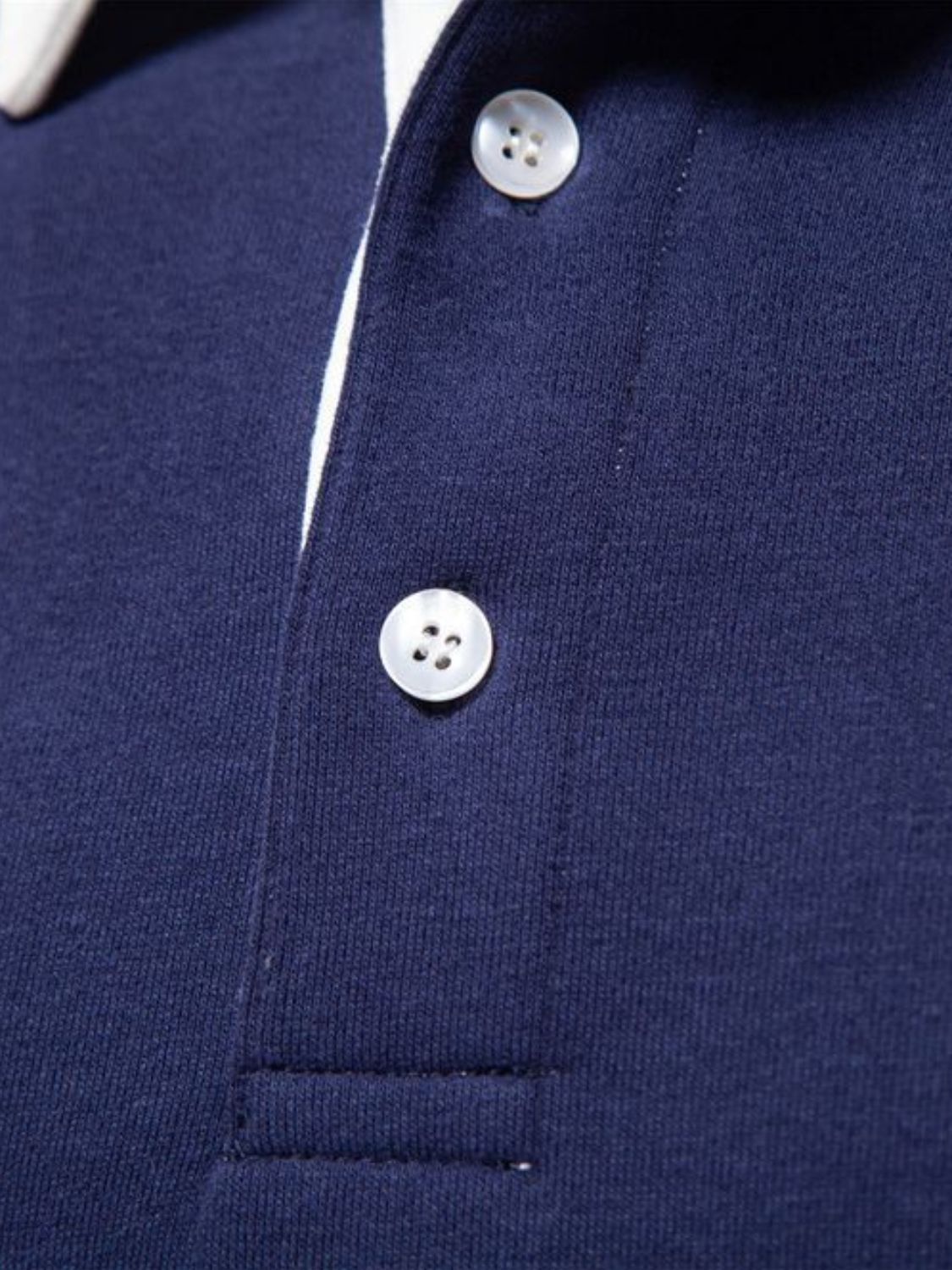 Men's quarter button collared neck polo close-up in navy blue.