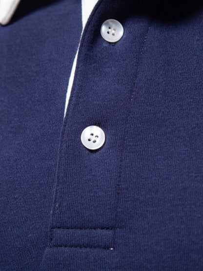 Men's quarter button collared neck polo close-up in navy blue.