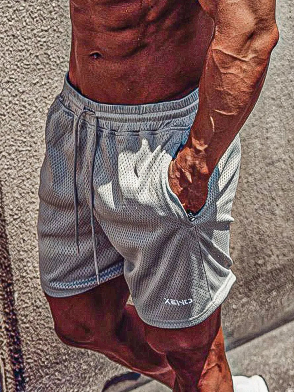 Men's plus size drawstring breathable shorts in grey worn outdoors.
