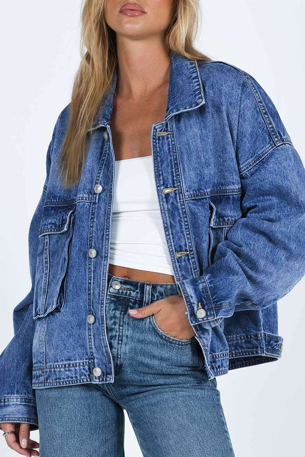 Collared neck button up denim jacket with front pockets and white buttons.