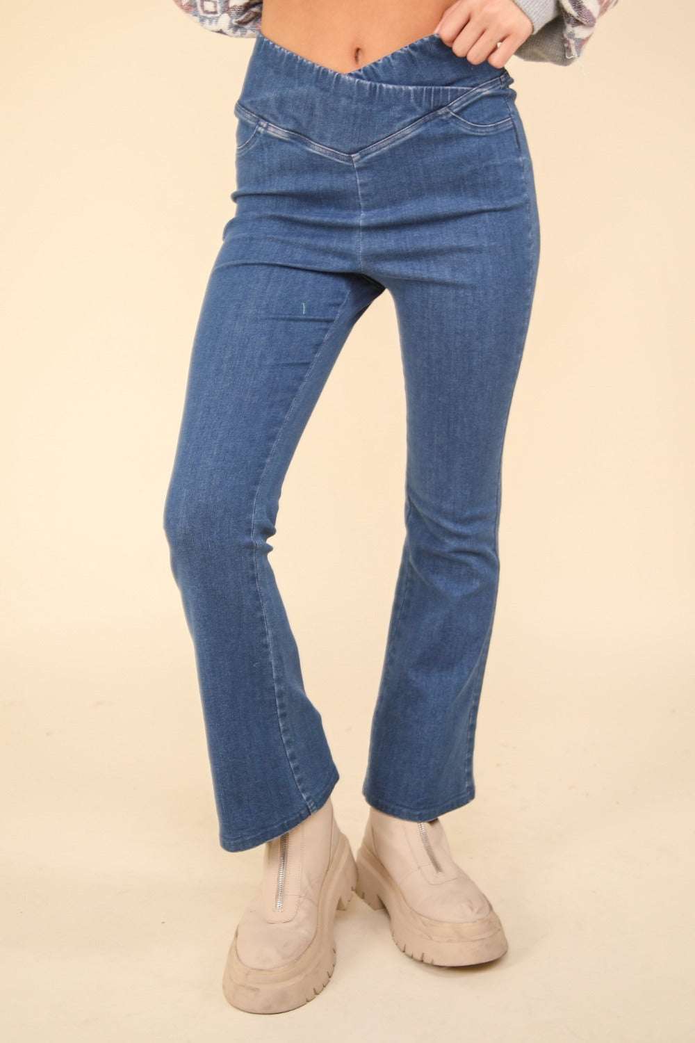 Washed denim stretchy crossover waist leggings with flared legs.