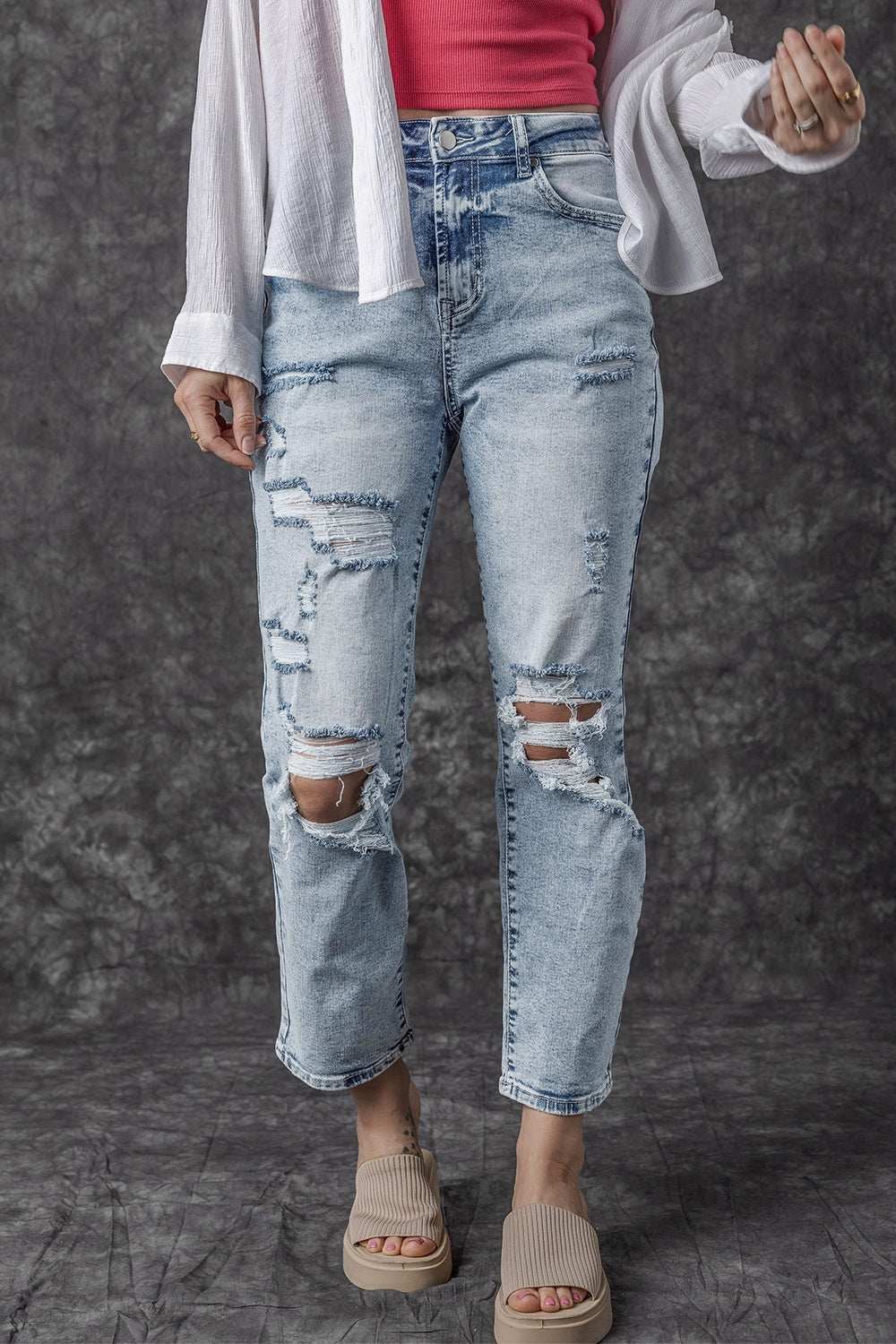 Distressed high waist jeans with no stretch, featuring a light blue denim and ripped detailing.