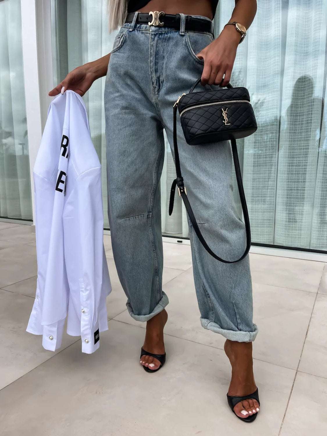 High waist wide leg jeans with pockets, buttoned front, worn with black belt and accessories.