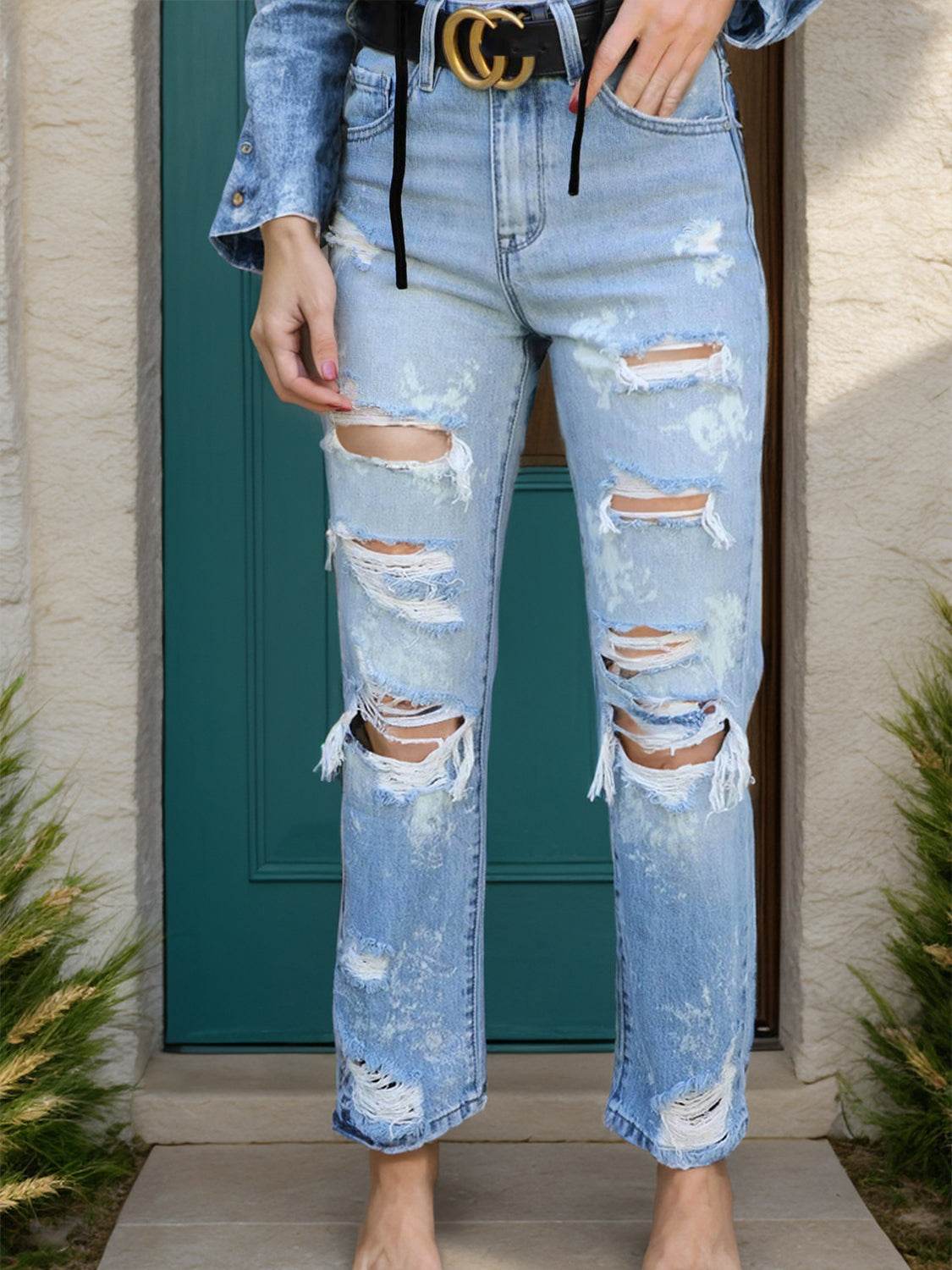 Distressed straight jeans with pockets featuring ripped design and slightly stretchy fabric.