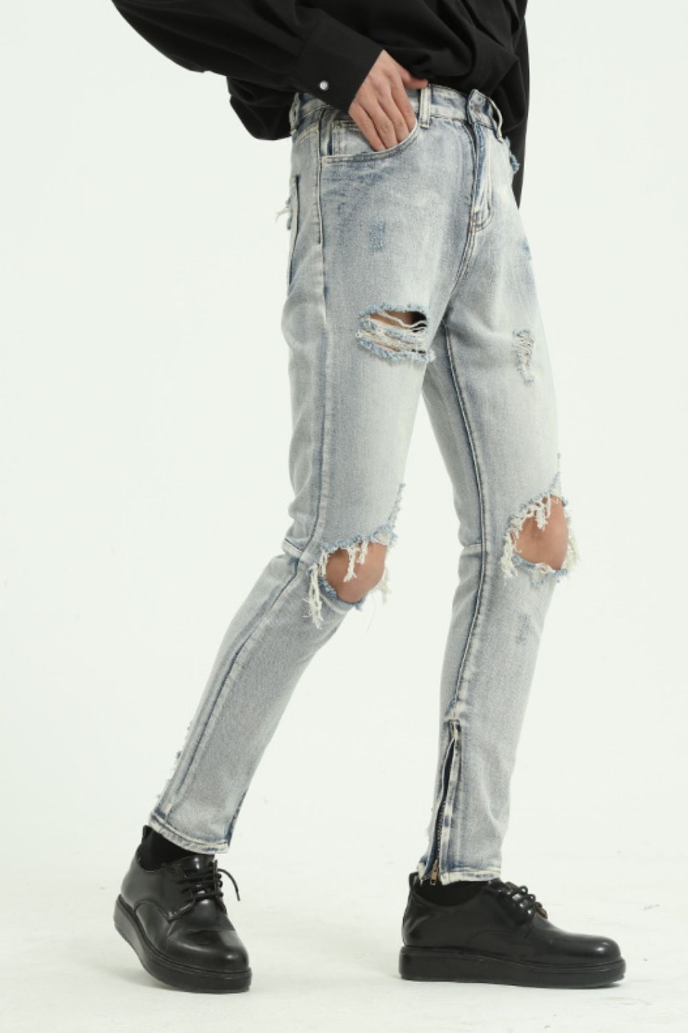 Pocketed distressed jeans with side zip, cotton blend, and no stretch, featuring a light wash and ripped details.