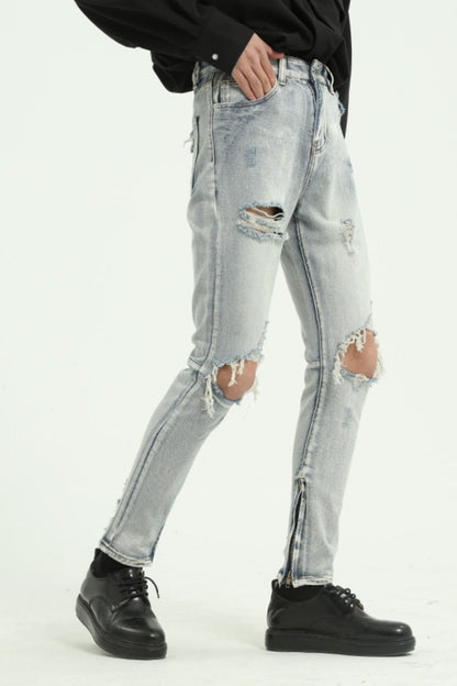 Pocketed distressed jeans with side zip, cotton blend, and no stretch, featuring a light wash and ripped details.