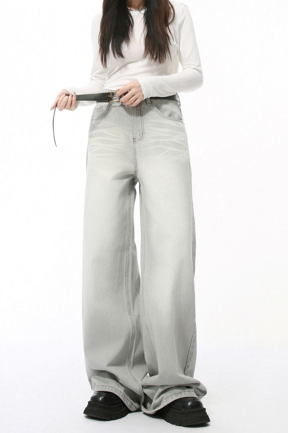 Wide leg jeans with pockets in light gray worn by a model.