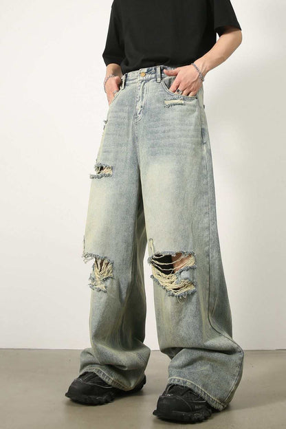 Men's distressed wide leg jeans with raw hem and vintage look.