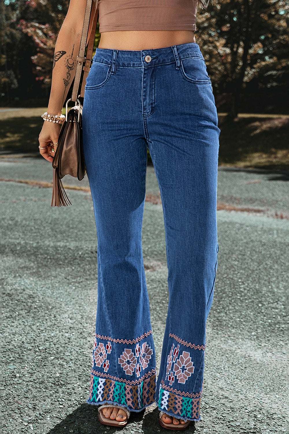 Embroidered bootcut jeans with decorative hem and classic blue denim style.