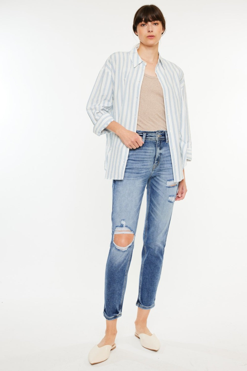 High rise distressed mom jeans with knee rip, paired with a striped shirt and white flats.