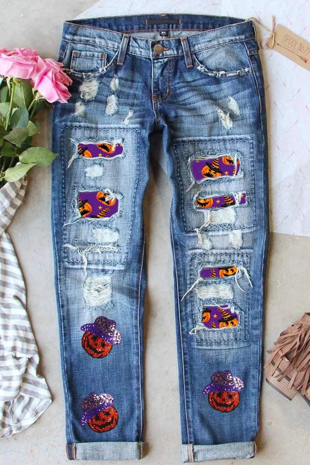 Distressed sequin pumpkin jeans with ripped details and colorful sequin patches.