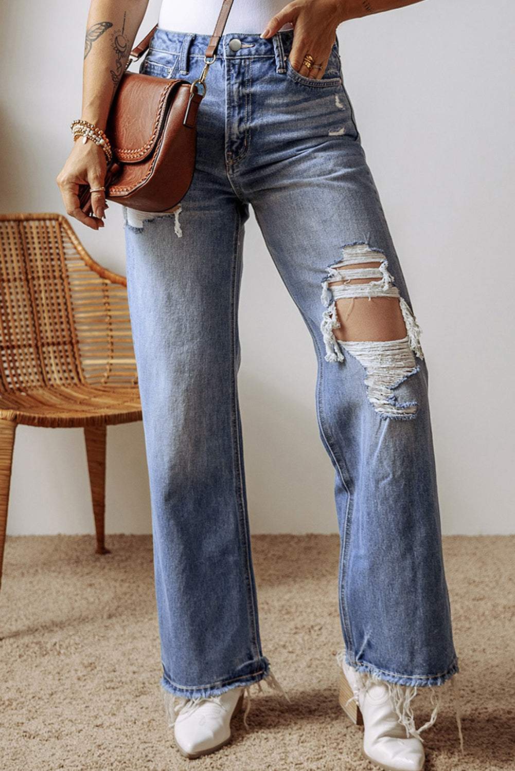 Distressed straight leg jeans with raw hem and pocket details.
