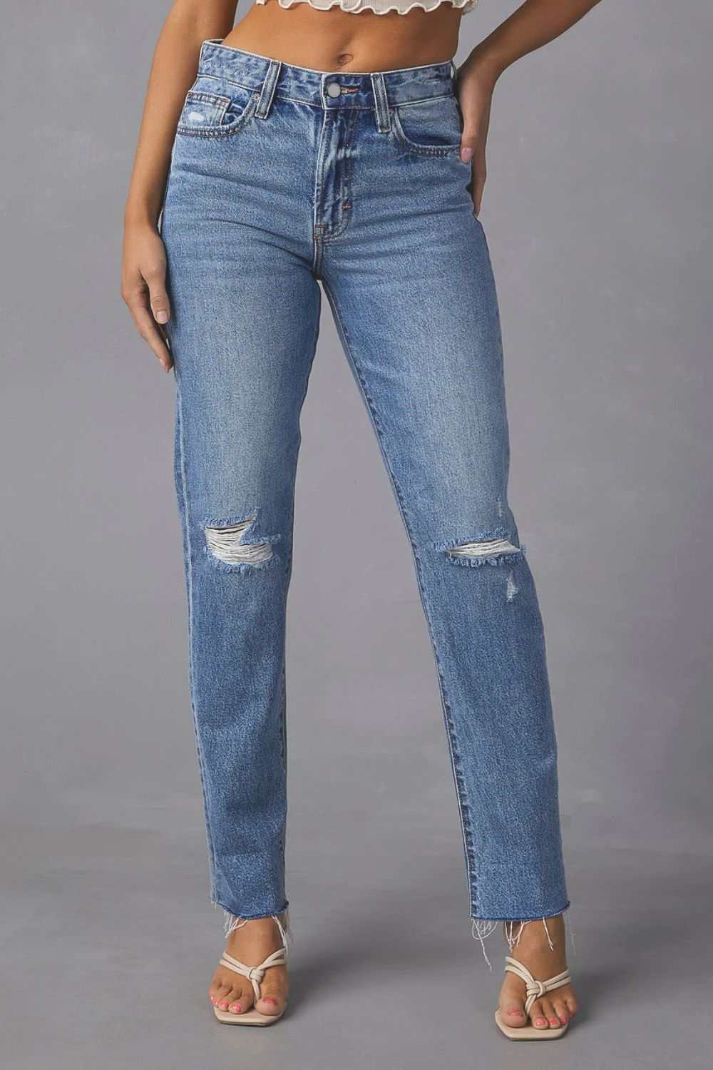 Distressed raw hem straight jeans with pockets and moderate stretch.