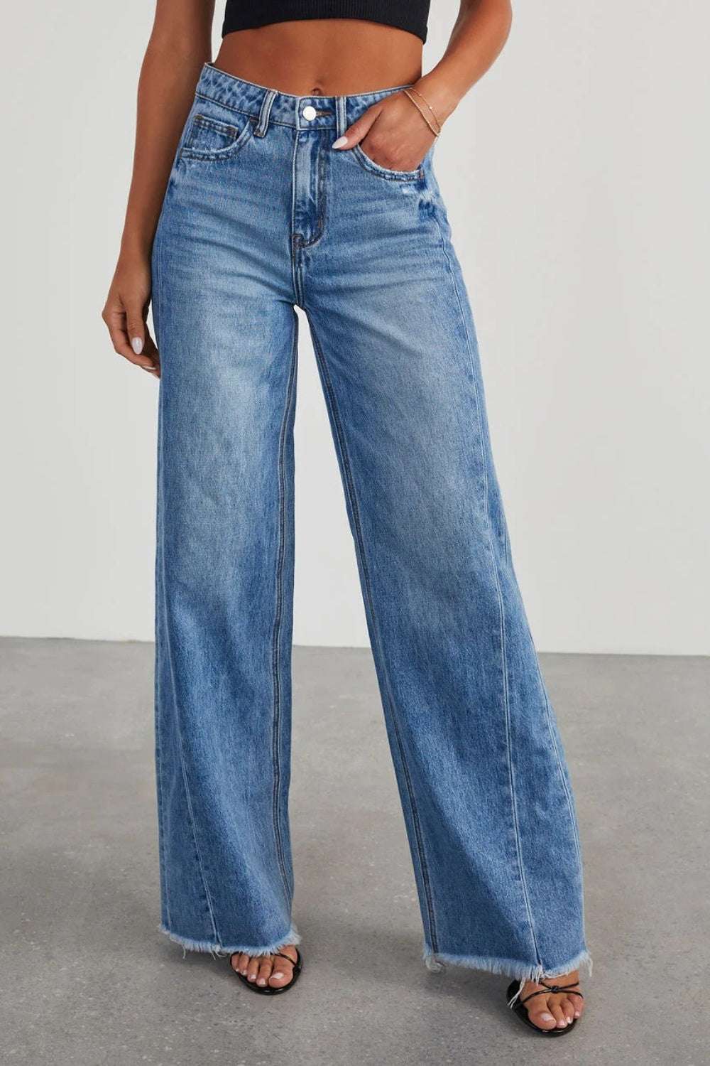 Wide leg denim jeans with raw hem and pockets.